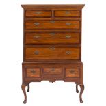 An 18th Century elm and crossbanded chest on stand:, the upper part with a moulded cornice,