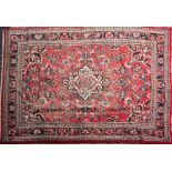 A Turkish carpet:, the rose field with a central ivory shaped lozenge pole medallion,