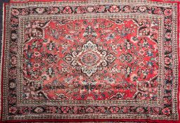 A Turkish carpet:, the rose field with a central ivory shaped lozenge pole medallion,