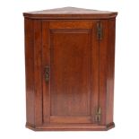 A George III oak hanging corner cupboard, last quarter 18th century,