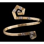 A diamond-set bangle of scroll design,: the terminals set with eight cut diamonds, on a reeded band,