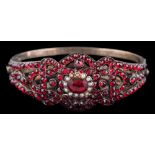 A late 19th century Russian garnet and seed pearl hinged bangle,