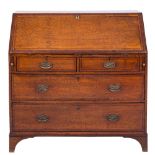 An early 19th Century oak, crossbanded and inlaid bureau:, bordered with ebony lines,