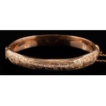 A 9 carat gold bracelet,: the hinged bracelet with engraved foliate decoration,