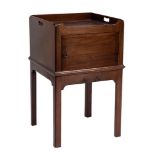 A George III mahogany adapted square tray top bedside cupboard:, with carrying handles to the sides,