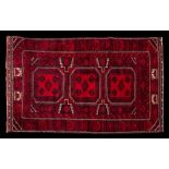 A Turkoman rug:, the wine field with triple rose octagonal medallions,