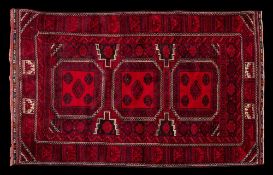 A Turkoman rug:, the wine field with triple rose octagonal medallions,