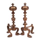 A pair of 19th century brass andirons: with knopped stem and finial on paw front feet and swept
