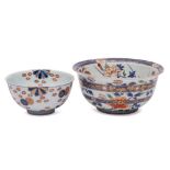 Two Japanese Imari bowls: the larger with flared rim and painted overall with peony, chrysanthemum,