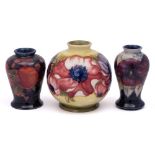 A group of three William Moorcroft vases: comprising a miniature baluster vase in the 'Pansy'