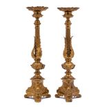 A pair of Italianate gilt brass candlesticks: the urn-shaped sconces with foliate decoration,