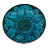 A Kashan pottery saucer dish: of shallow circular form painted in black with stylised bud motifs on