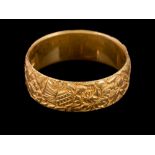 An 18 carat gold ring,: the band with foliate decoration,