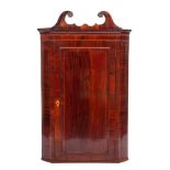 A George III mahogany and inlaid hanging corner cupboard:, bordered with boxwood lines,