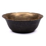 An oriental bronze bowl: of plain circular form with wavy edge border, 18cm diameter.