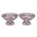 A pair of Meissen [outside decorated] reticulated tazze: the pedestals moulded with ribbon tied