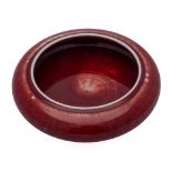 A small Chinese copper red glazed brush washer: of compressed bombe form, 12cm.