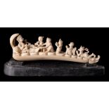 An Indian carved ivory figure group: of a diety reclining on coiled snakes with musicians and