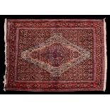 A Senneh rug:, the indigo field with a central ivory bordered stepped lozenge medallion,