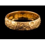 A 22 carat gold ring,: the band with chased foliate decoration,