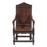 A 17th Century and later oak open armchair:, the panelled back with angled arch cresting,