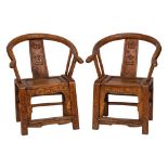A pair of Chinese carved softwood armchairs:, of curved outline,