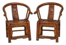 A pair of Chinese carved softwood armchairs:, of curved outline,