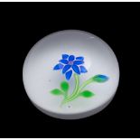 A Baccarat flower paperweight: set with a blue double flower and bud on a sodden snow ground set