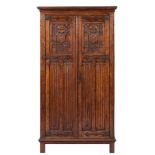 An oak wardrobe in Gothic revival taste, early 20th century,: with moulded cornice above twin doors,