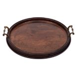 A Georgian mahogany serving tray: of circular outline with moulded border and brass loop carrying
