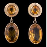 A pair of citrine earrings: each set with a circular cut citrine suspending an oval cut citrine