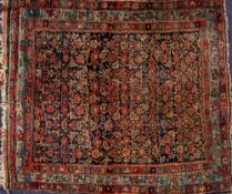 A Feraghan rug:, the indigo field with an all over geometric flowerhead and foliate design,