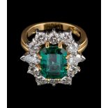 An 18 carat gold emerald and diamond ring,: the central rectangular cut emerald stated to weigh 3.