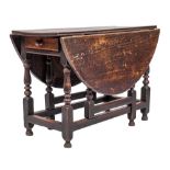 An 18th Century oak oval gateleg dining table:, with a hinged top, the frieze fitted with a drawer,