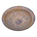 A Persian pottery dish: of shallow circular form with everted rim,