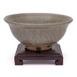 A Thai Sawankhalok celadon glazed bowl: the interior incised with a band of scrolling foliage