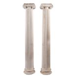A pair of composition plaster fluted columns:, with Ionic capitals, on circular bases,