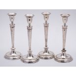 A set of four 19th Century silver plated candlesticks: with plain urn-shaped sconces on slender