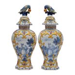 A pair of Dutch polychrome delftware vases and covers: with parrot and fruit finials,