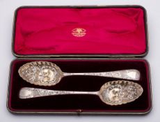 Two George III silver Old English pattern and later decorated berry spoons,