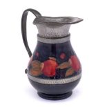 A William Moorcroft pewter mounted jug: decorated in the Pomegranate pattern, the mounts hammered,