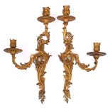 A pair of 19th century French gilt brass twin-light wall sconces: the urn-shaped sconces on