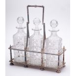 An Edwardian silver plated three decanter stand: of rectangular outline with beaded decoration and