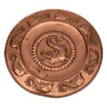 A Newlyn-style copper charger: the centre with embossed fish within a scaly border,