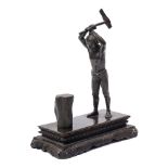 A bronze statue of an Asian native chopping wood: unsigned,