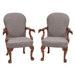 A pair of carved walnut open armchairs in the early 18th Century manner:,