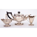 A George V silver three-piece batchelor's pedestal tea set, maker Henry Matthews, Birmingham,