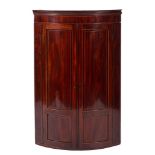An early 19th Century mahogany and inlaid bow-fronted hanging corner cupboard:,