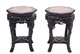 A pair of Chinese carved hardwood urn stands: of beaded octagonal outline the tops inset with a