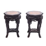 A pair of Chinese carved hardwood urn stands: of beaded octagonal outline the tops inset with a